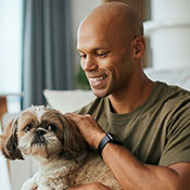 Smiling veteran petting a dog