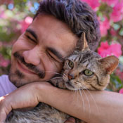 Man hugging cat lovingly